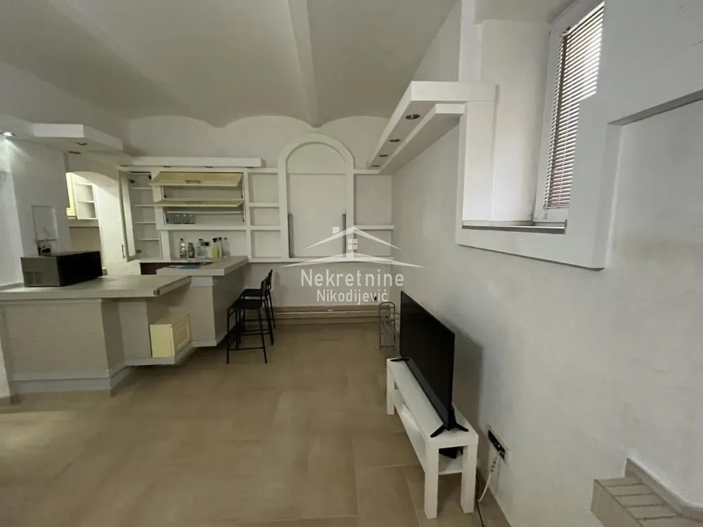 Living room with a bar counter and kitchen area in the background.
