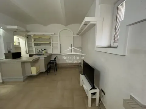 Living room with a bar counter and kitchen area in the background. - image 5