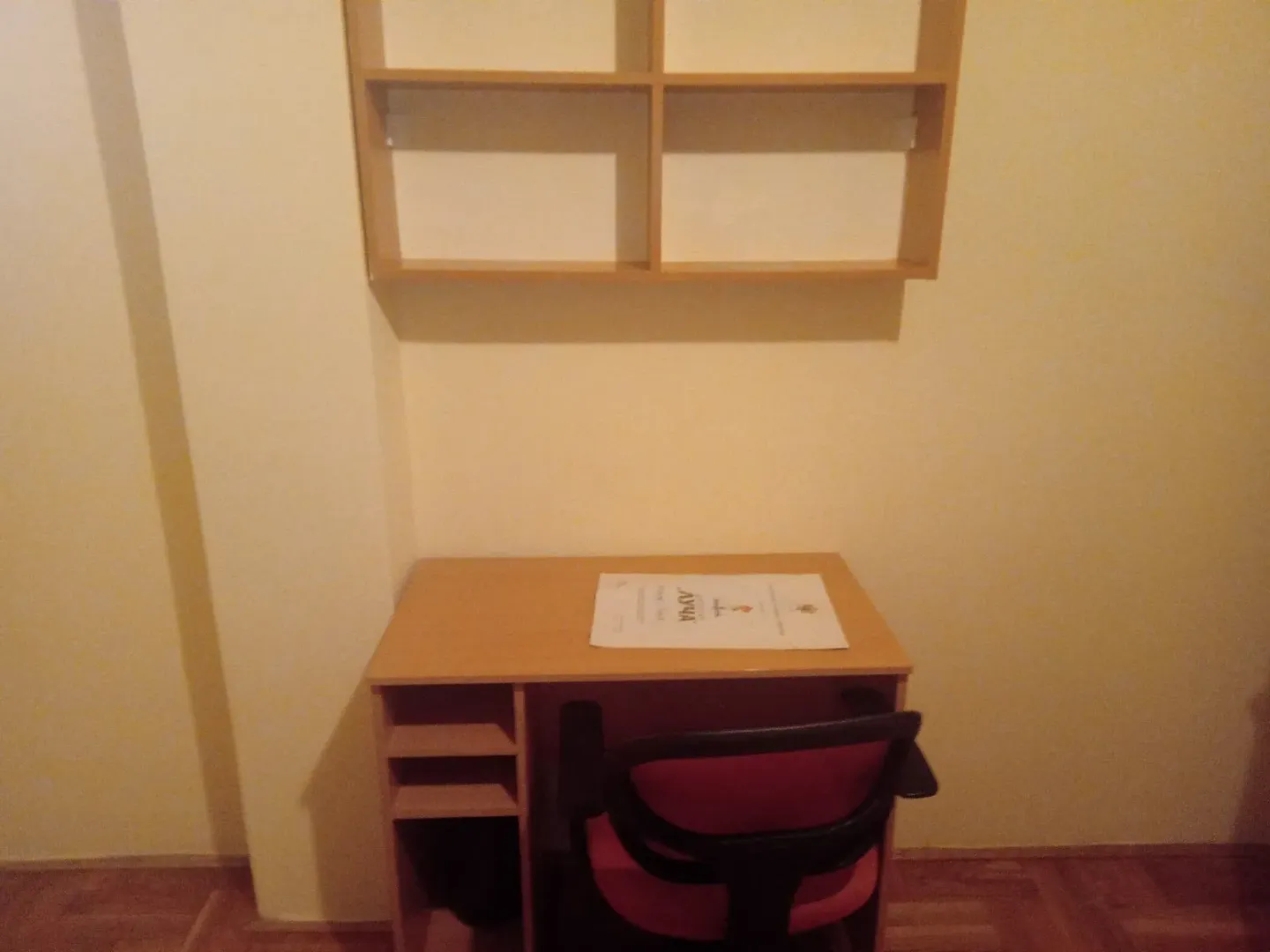 Radni kutak sa stolom, stolicom i zidnom policom.