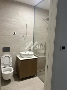 Modernly equipped bathroom with a washbasin, toilet bowl, and glass shower cabin. - image 8