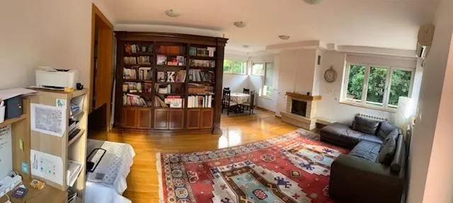 Spacious living room with a fireplace, large bookcase and a sofa set.