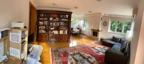 Spacious living room with a fireplace, large bookcase and a sofa set. - image 2