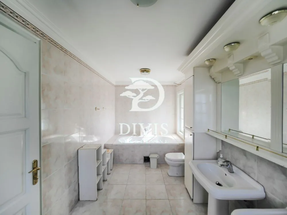 Spacious bathroom with a bathtub, sink, and built-in cabinetry.