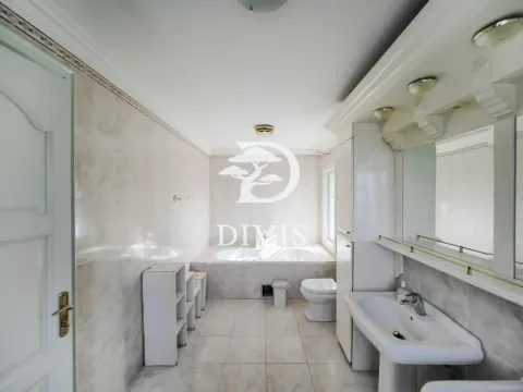Spacious bathroom with a bathtub, sink, and built-in cabinetry. - image 12
