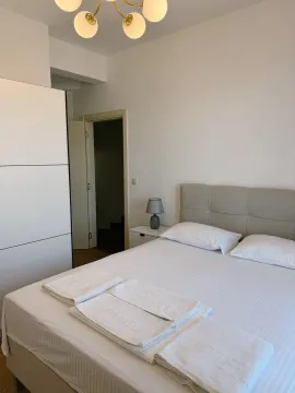 Bedroom with a double bed, white wardrobe, and folded towels. - image 5