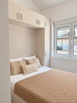 Bright bedroom with built-in wardrobes and a double bed. - image 12