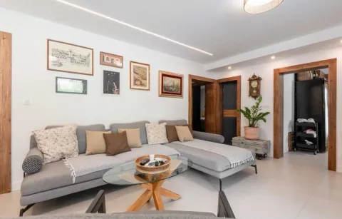 Living room with a sectional sofa, coffee table, and wall art. - image 6