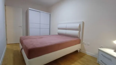 Bright and tidy bedroom with a double bed, wardrobe, and nightstand. - image 5