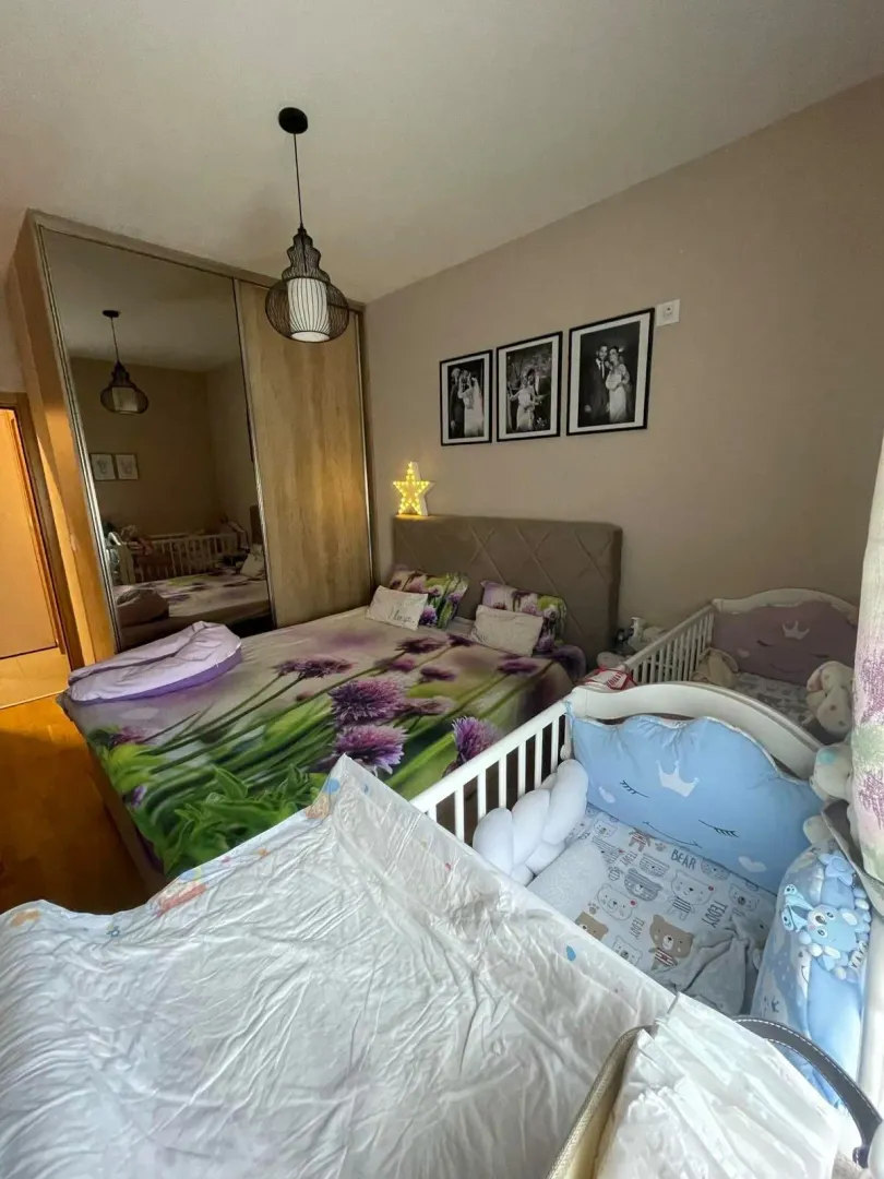 Namještena spavaća soba sa bračnim krevetom i dječijim krevecima.