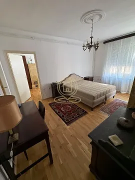Furnished bedroom with a double bed, desk, and parquet flooring. - image 11