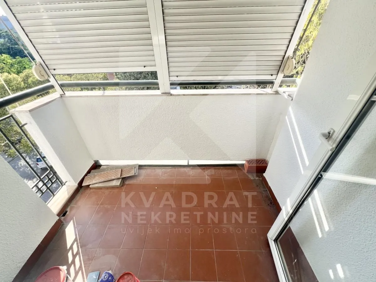 Manji zatvoreni balkon sa keramičkim pločicama i roletnama.