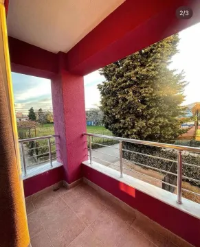 Covered terrace with red pillars and a metal railing. - image 8