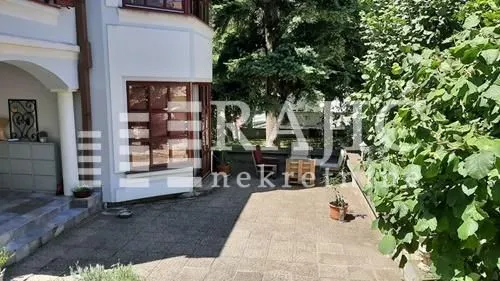Paved yard in front of the house with seating furniture.