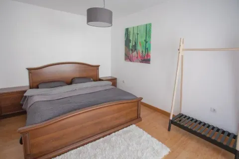 Spavaća soba sa velikim drvenim bračnim krevetom i noćnim stočićima. - image 11