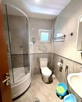 Manje kupatilo obloženo keramičkim pločicama sa tuš kabinom i toaletom. - image 19