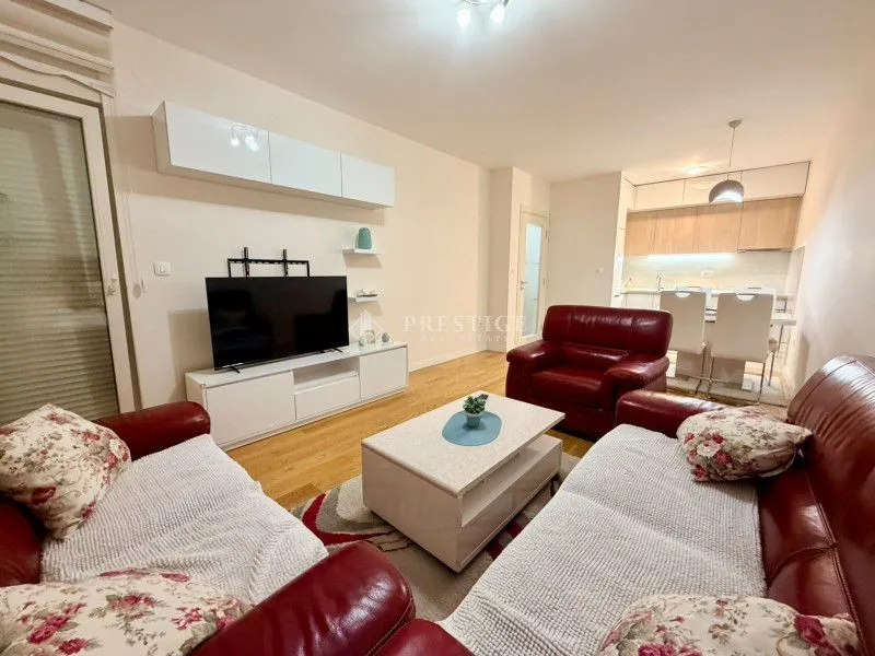 Furnished living room connected with dining area and kitchen.