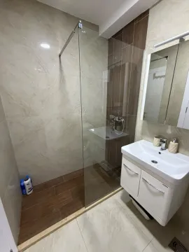 Modern bathroom with a walk-in shower and vanity sink. - image 5