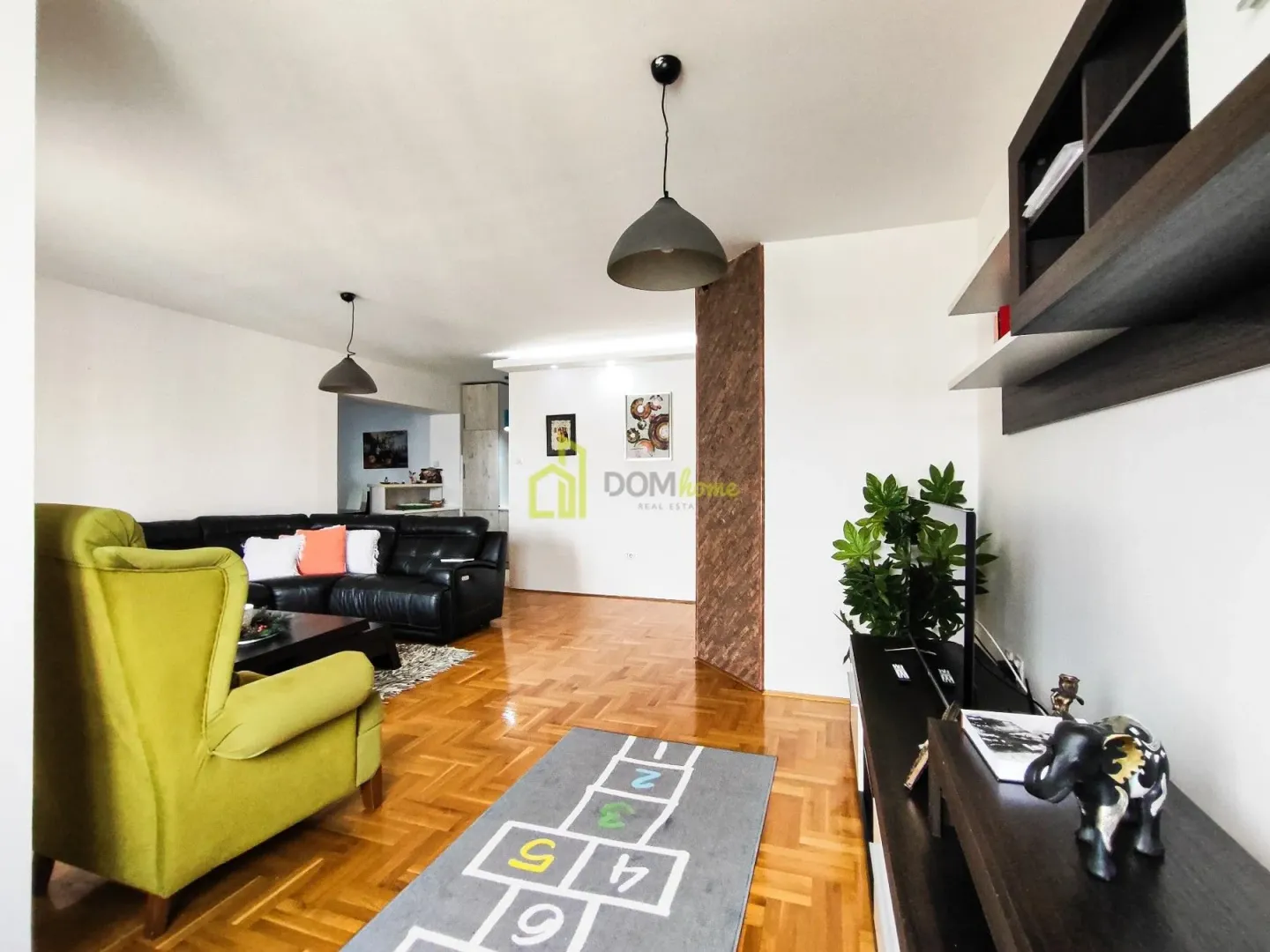 Living room with seating furniture and wooden flooring.
