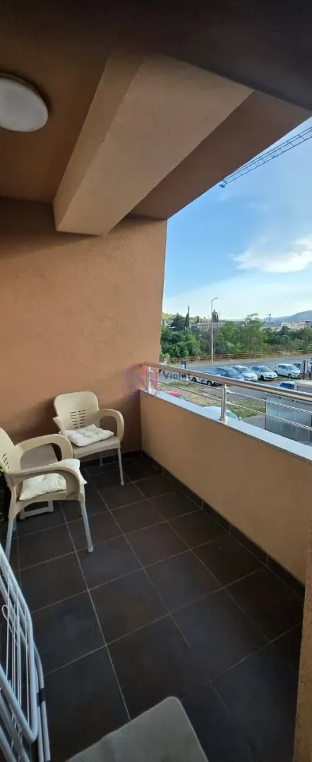 Covered balcony with seating furniture and a view of the surroundings.