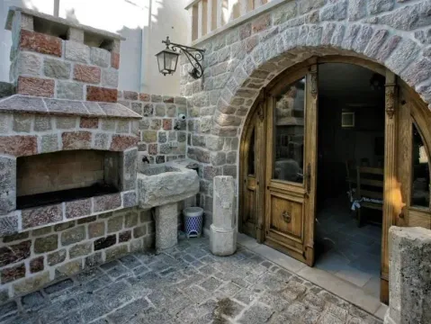 Stone courtyard featuring an outdoor fireplace and a decorative stone sink. - image 7