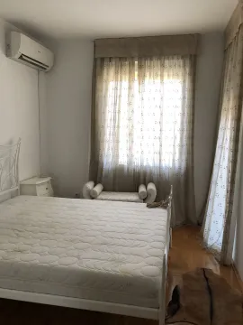 Bright bedroom featuring a bed, air conditioning unit, and elegant curtains. - image 23