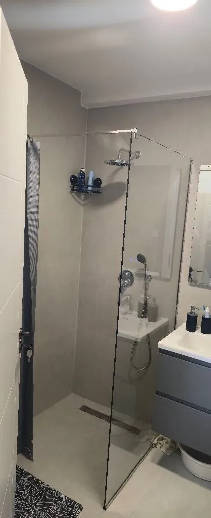 Modernly equipped bathroom with a walk-in shower and vanity unit.