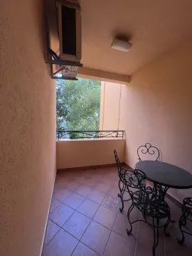 A narrow balcony with tiled flooring and a wrought iron seating set. - image 21