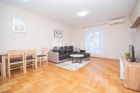 Living room with a sofa, dining table, and TV unit. - image 2