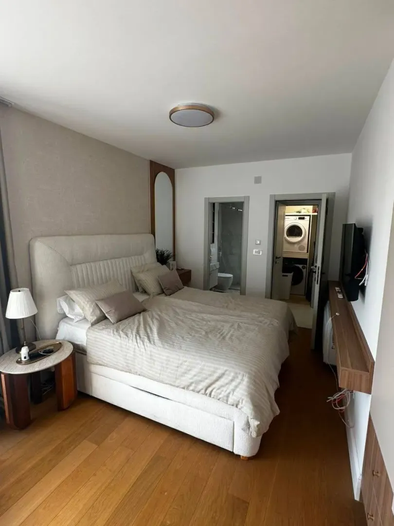 Modern bedroom with a double bed and a view into the bathroom.