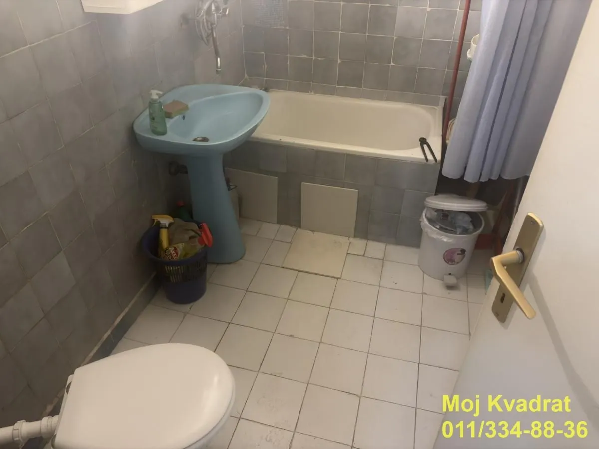 Bathroom equipped with a bathtub, washbasin, and toilet with tiled walls.