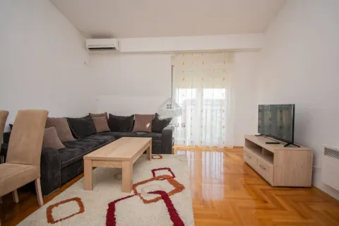 Dnevna soba sa garniturom, stočićem, televizorom i izlazom na terasu. - image 2