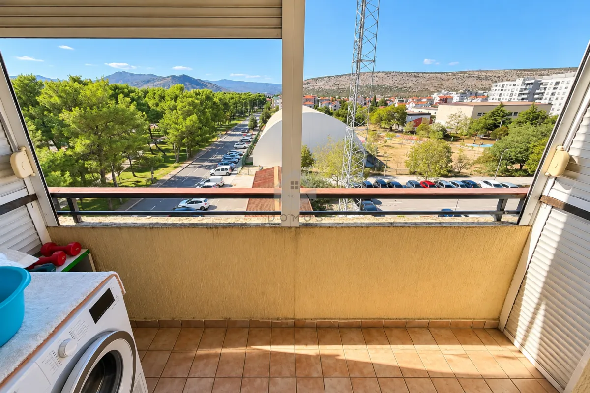 Natkriveni balkon sa pogledom na grad i okolinu.