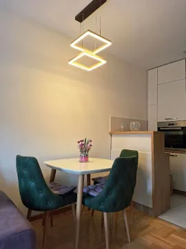 Trpezarija sa stolom, zelenim stolicama i modernim lusterom. - image 5
