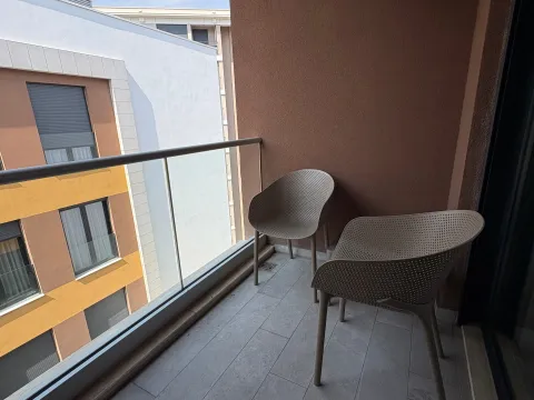 Namtještena terasa sa stolicama i pogledom na susjedne zgrade. - image 10