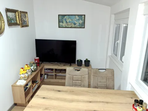 Dnevna soba sa drvenim stolom, policama i televizorom. - image 13