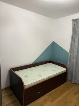 A simple bedroom featuring a single bed and a decorative painted wall. - image 8
