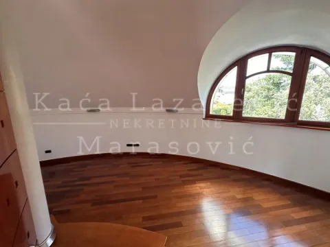 Prazna prostorija sa drvenim podom i velikim lučnim prozorom. - image 14