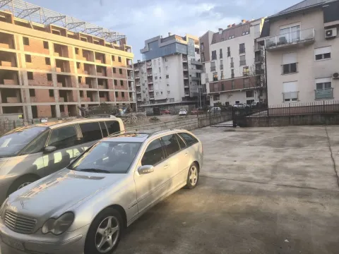 A courtyard with a parking area in front of residential buildings. - image 7