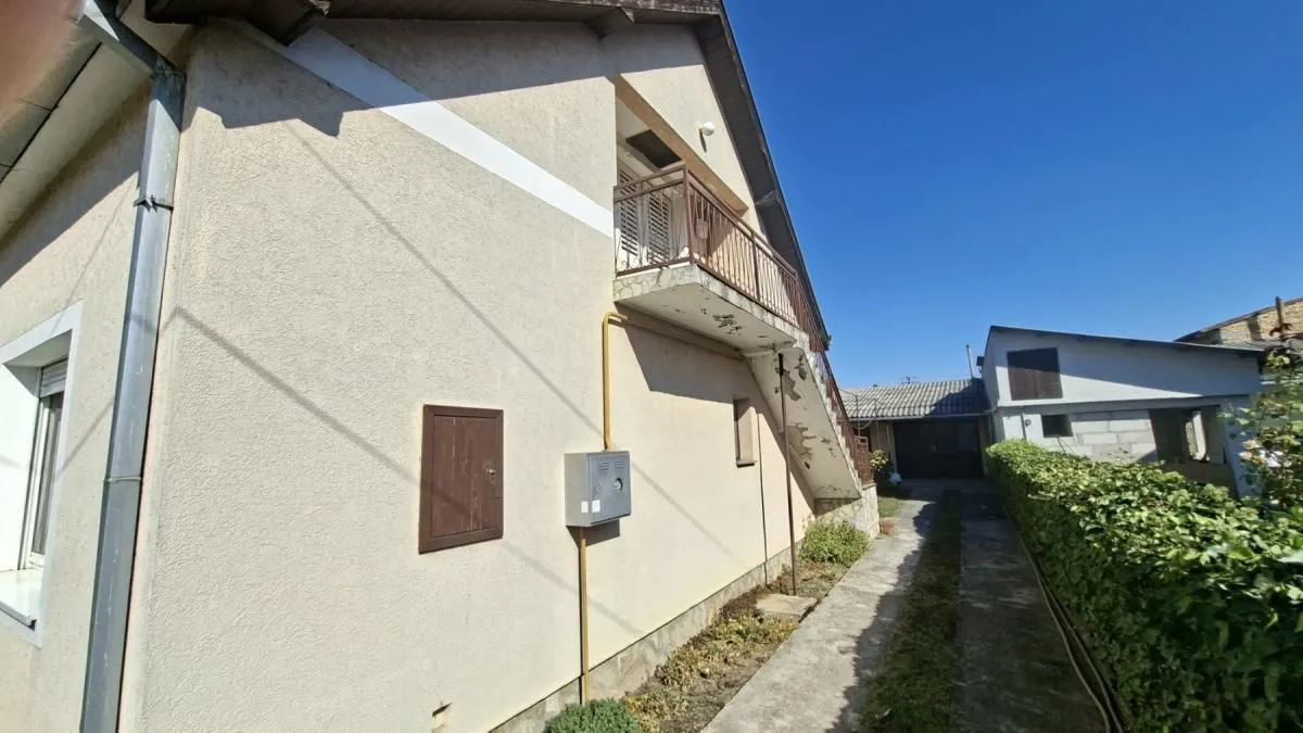 Bočna strana kuće sa spoljnim stepeništem i balkonom.