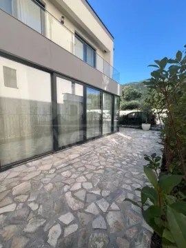 Exterior of the house with a paved yard and an upper-floor terrace. - image 10