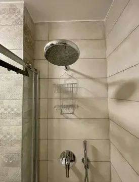 Krupni kadar tuš kabine sa slavinom i držačem za sapun na pločicama. - image 16
