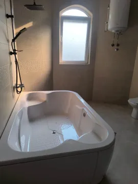 Modern bathroom with a bathtub and shower. - image 5