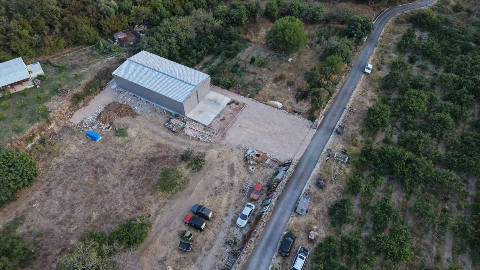 Aerial view of the property with a large warehouse and access road.