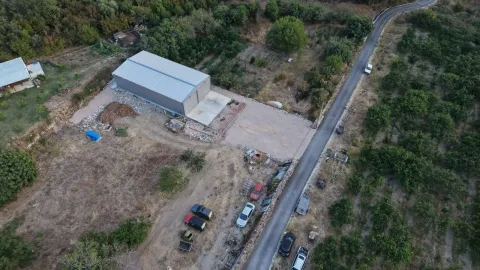 Aerial view of the property with a large warehouse and access road. - image 5