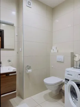 Savremeno opremljeno kupatilo sa umivaonikom, WC šoljom i veš mašinom. - image 2