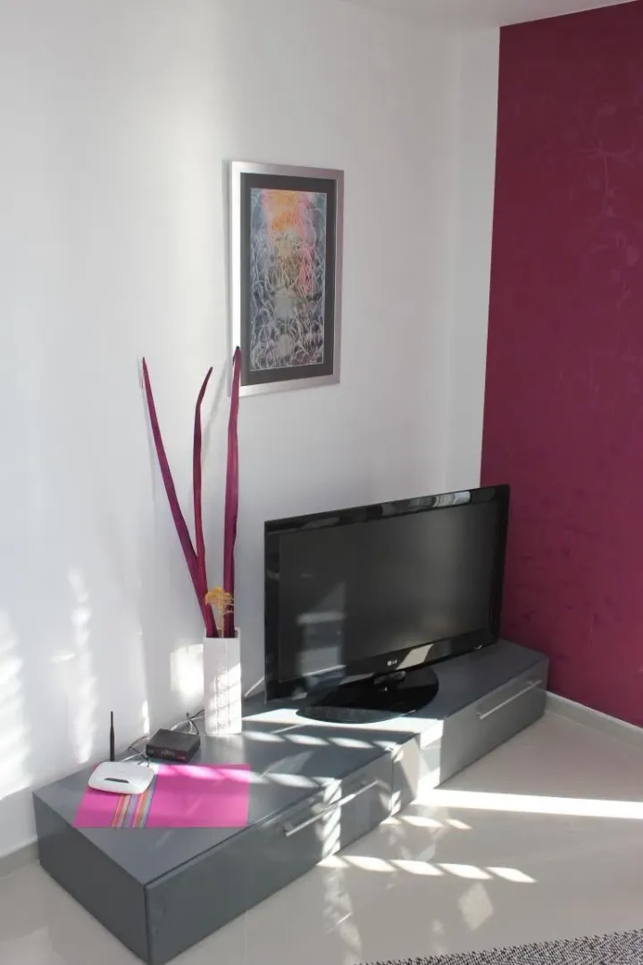 Living room with a TV and chest of drawers.