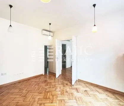 Empty room with parquet flooring and white walls. - image 2