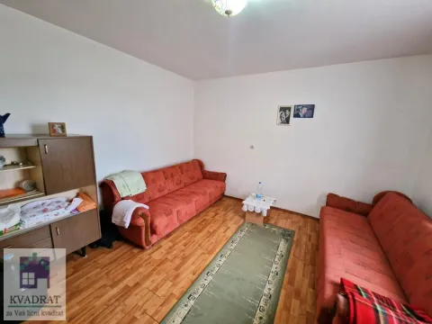 Dnevna soba sa dva crvena kauča i drvenim nameštajem. - image 10