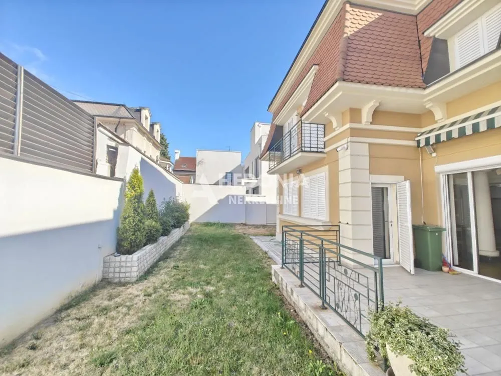 View of the courtyard and the facade of the house with a terrace.