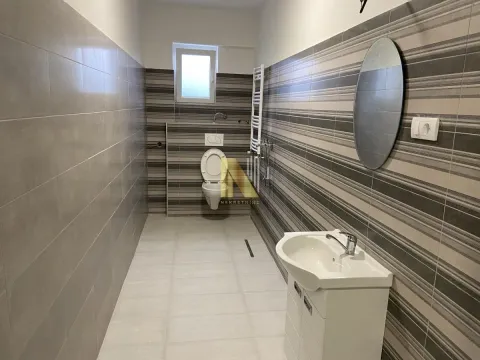 Long tiled bathroom with a sink and a toilet. - image 9